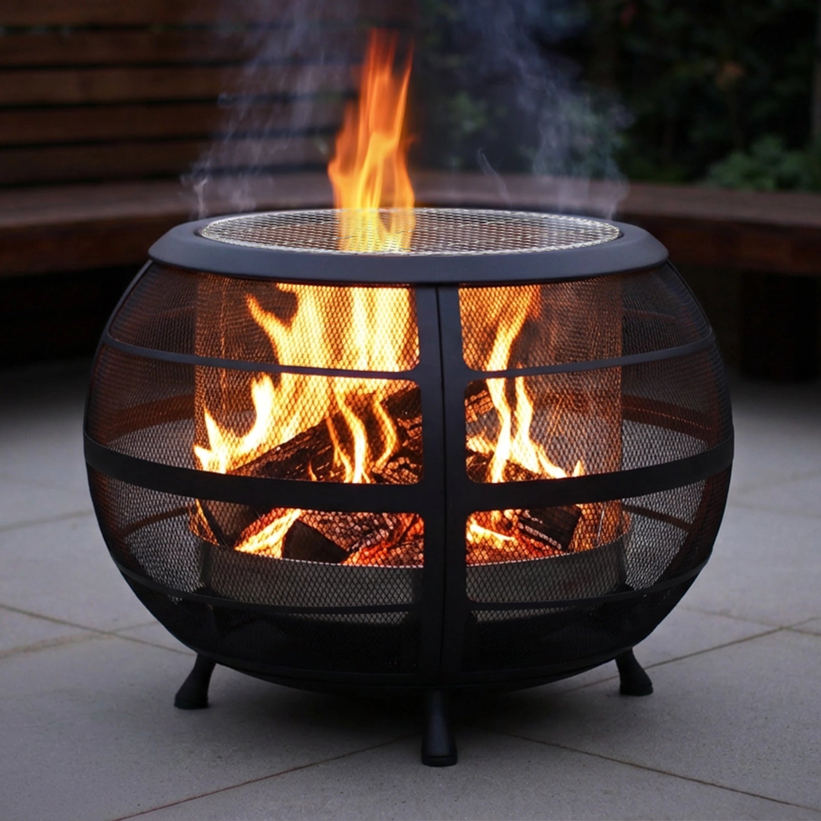 Black metal fire pit with flames on a patio